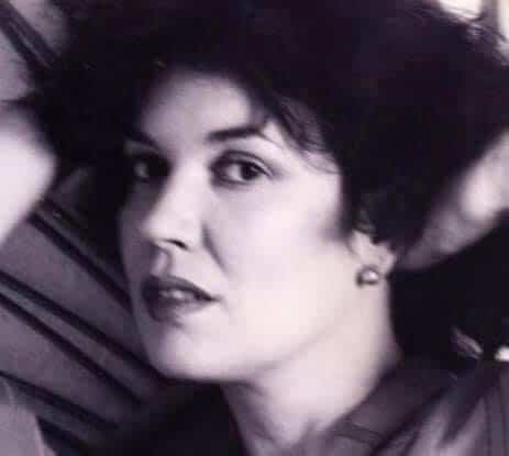A black-and-white close-up photo of a woman with short, tousled hair and captivating eyes.