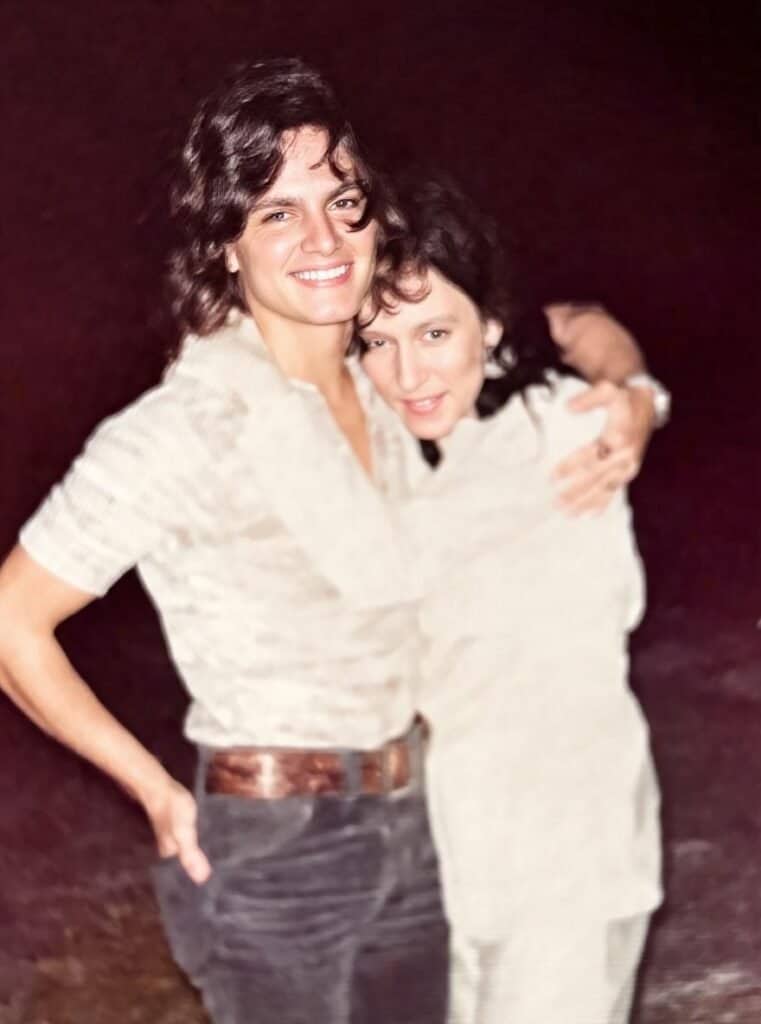 Two women smiling and hugging, celebrating friendship and happiness.
