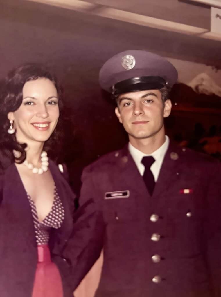 A woman and a man in a military uniform posing together at a formal gathering.